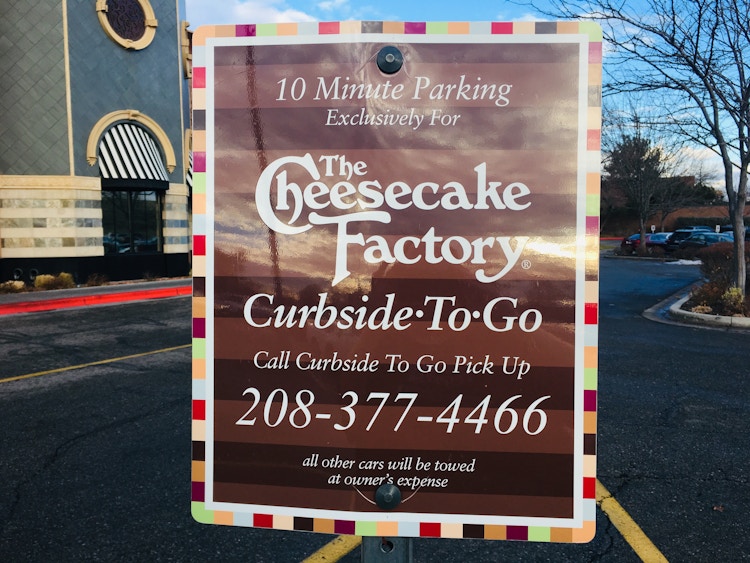 A 10 minute parking sign to designate the Curbside-to-go parking space outside of The Cheesecake Factory.