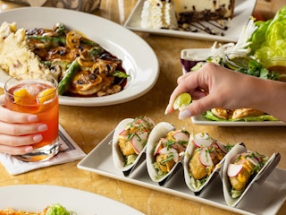 a hand squeezing a lime on taco at the cheesecake factory