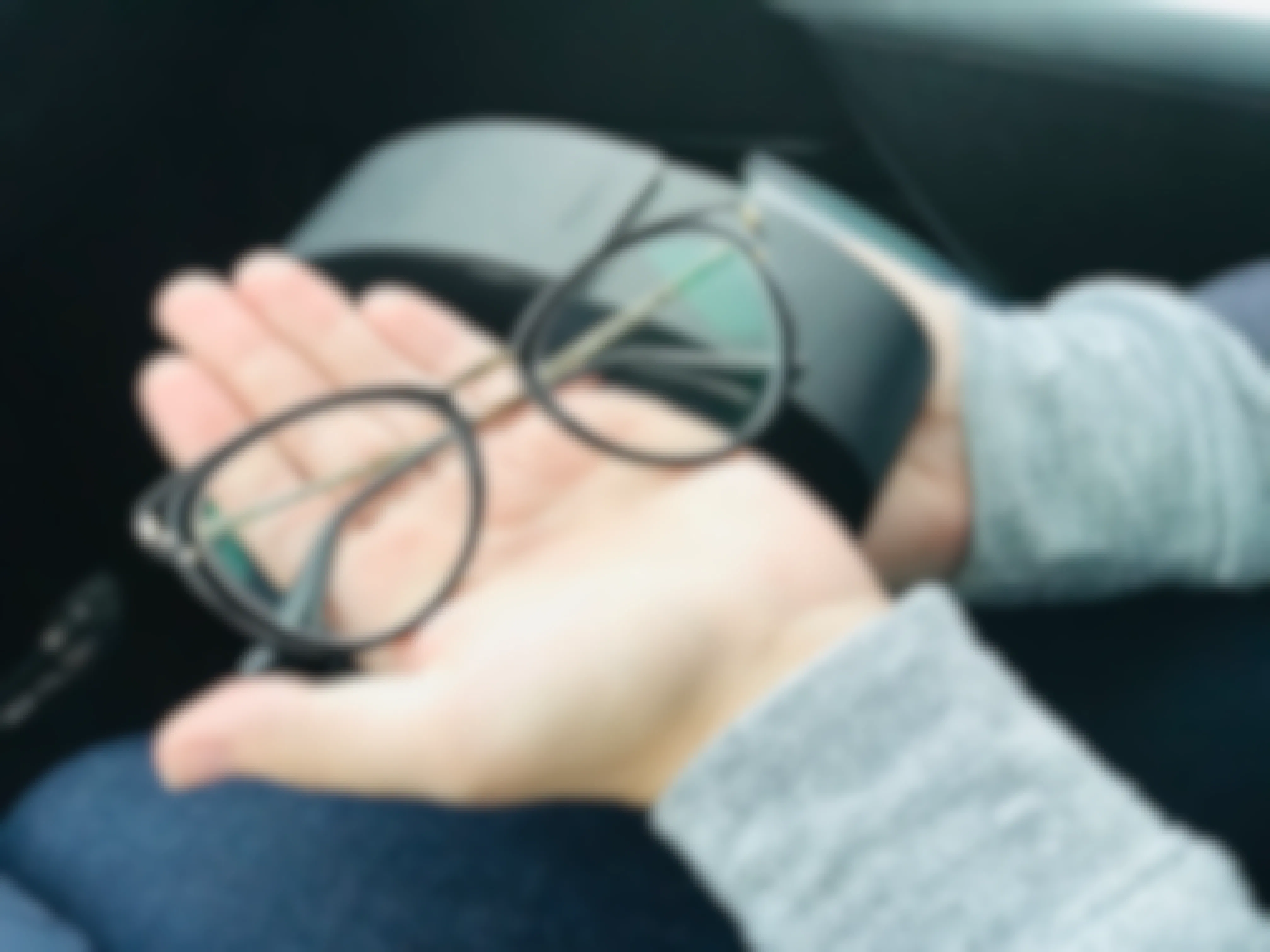 Open hand displaying a new pair of eyeglasses.
