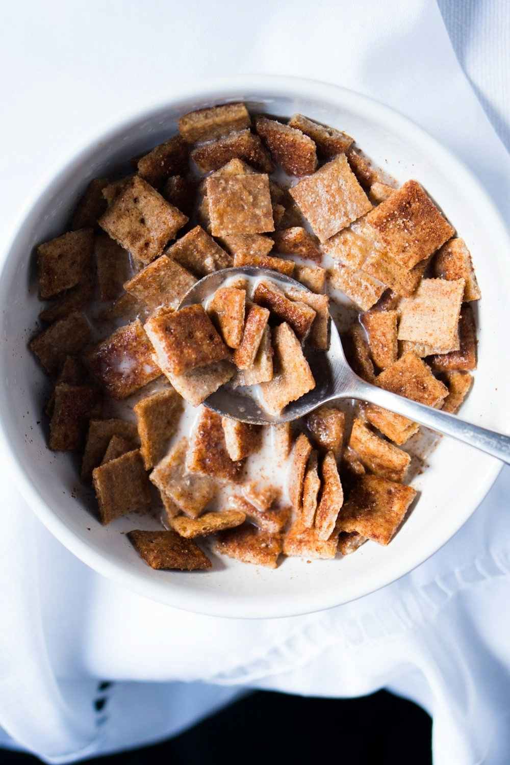 homemade cinnamon toast crunch cereal in a bowl with milk