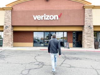 a person walking into outside a verizon store
