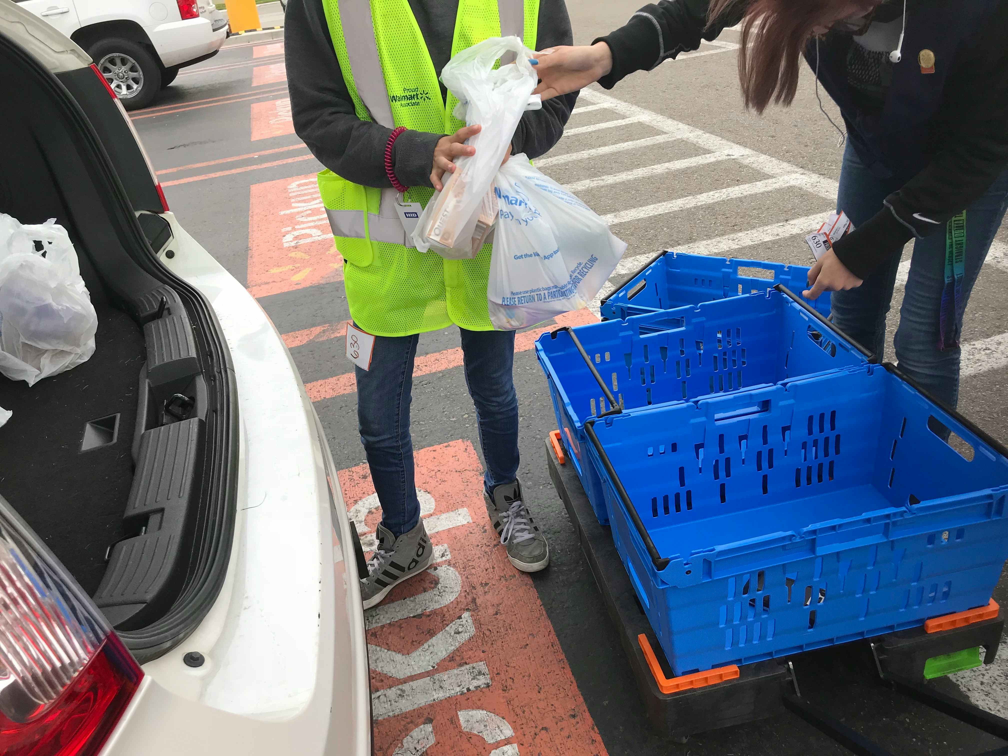 Walmart grocery pickup order handled by store associate in the Walmart parking lot