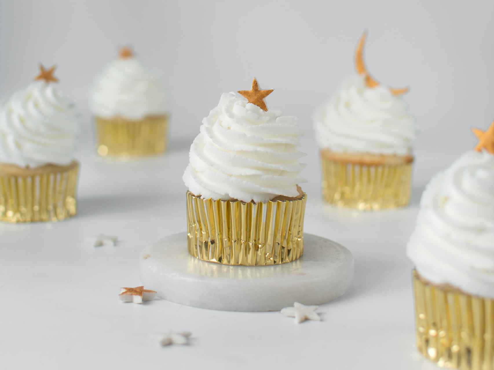 Some vanilla cupcakes with shiny decorations