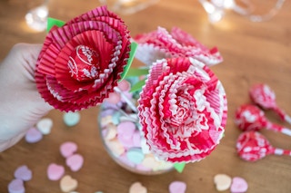 someone holding tootsie pop with cupcake wrappers around it