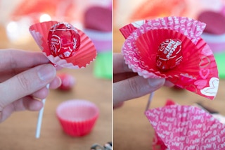 someone holding tootsie pop with cupcake liner around it