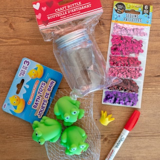 toy frogs next to mason jar and sequins