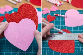 someone holding felt hearts and using exacto knife on it