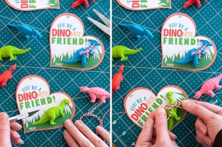someone holding exacto knife next to youre a dinomite friend card and tying a toy dinosaur to it
