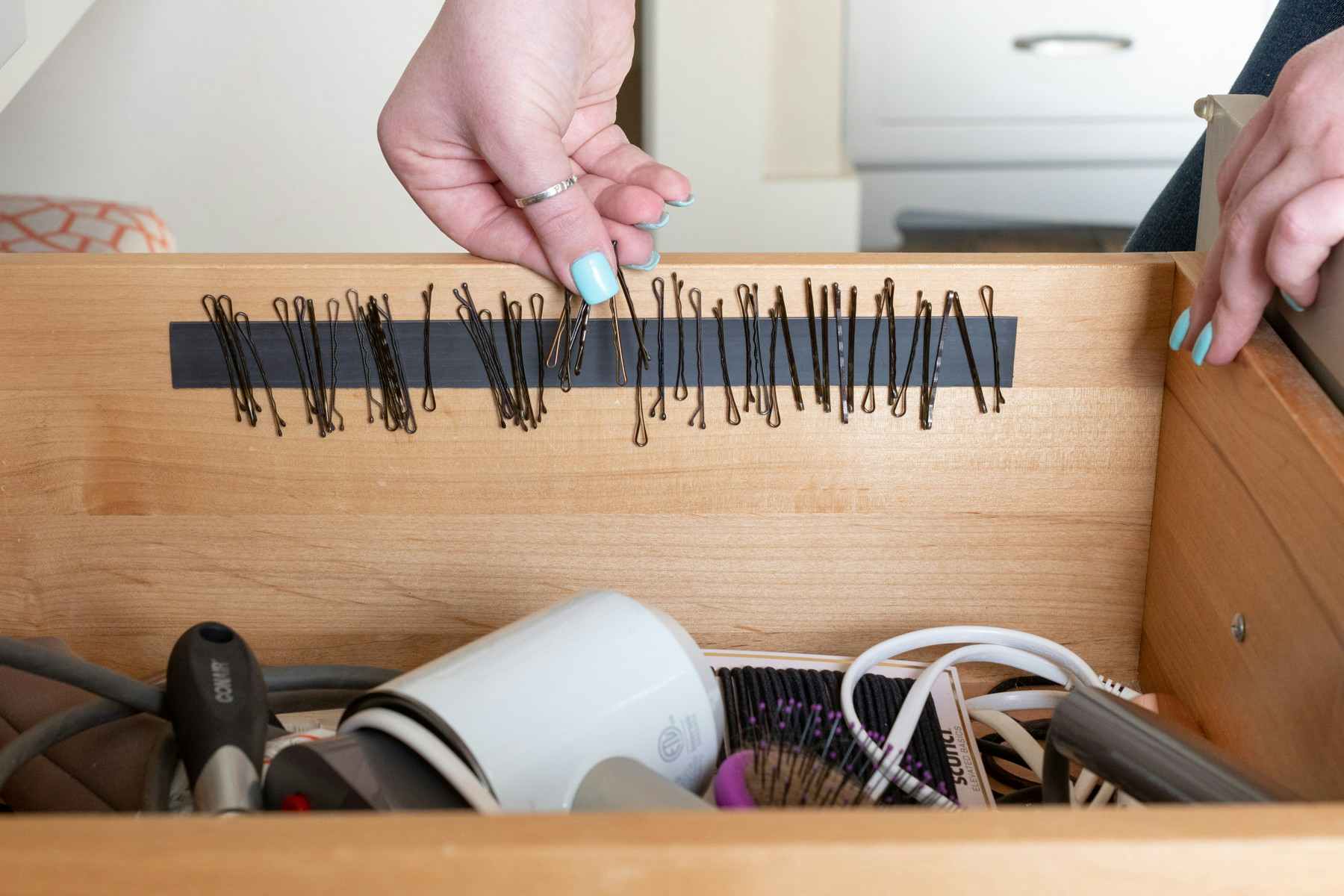 someone sticking bobby pins on magnetic strip