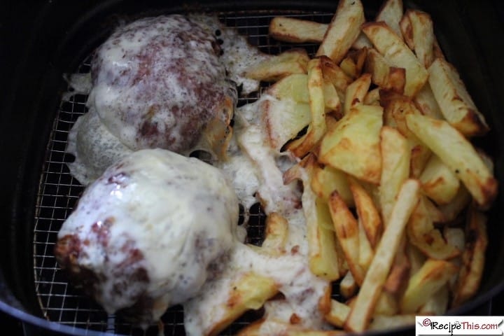 burger patties smothered in cheese with fries in the same air fryer basket