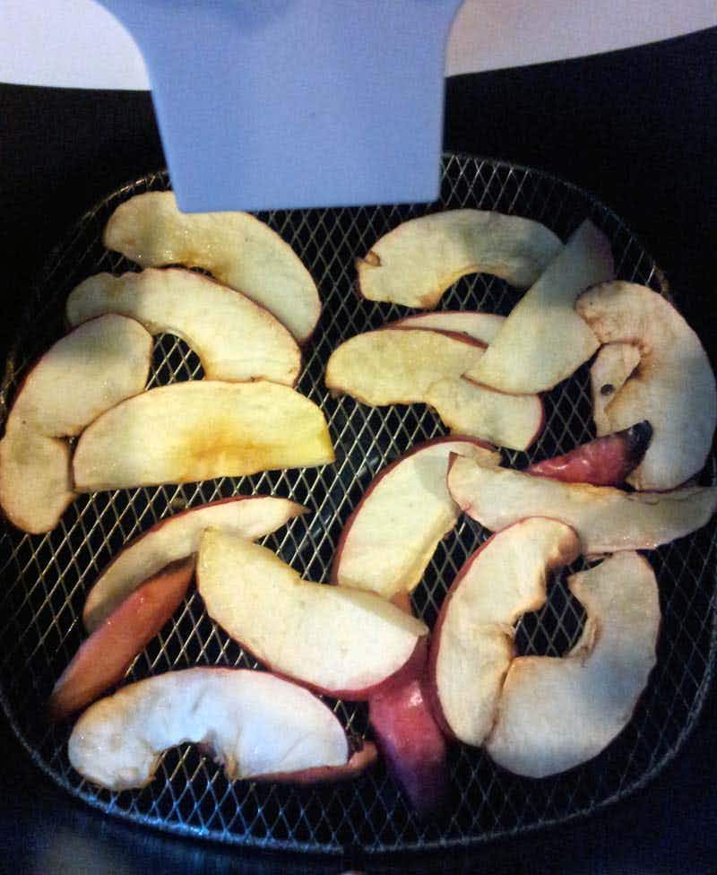 apple slices being cooked in an air fryer