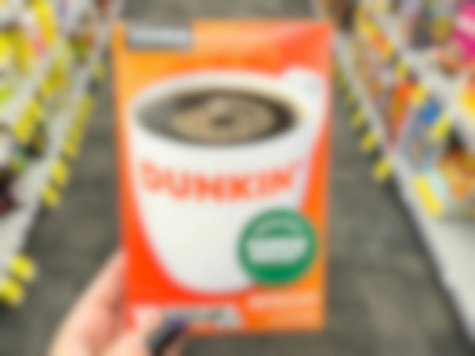 a person holding up dunkin k cups in a cvs