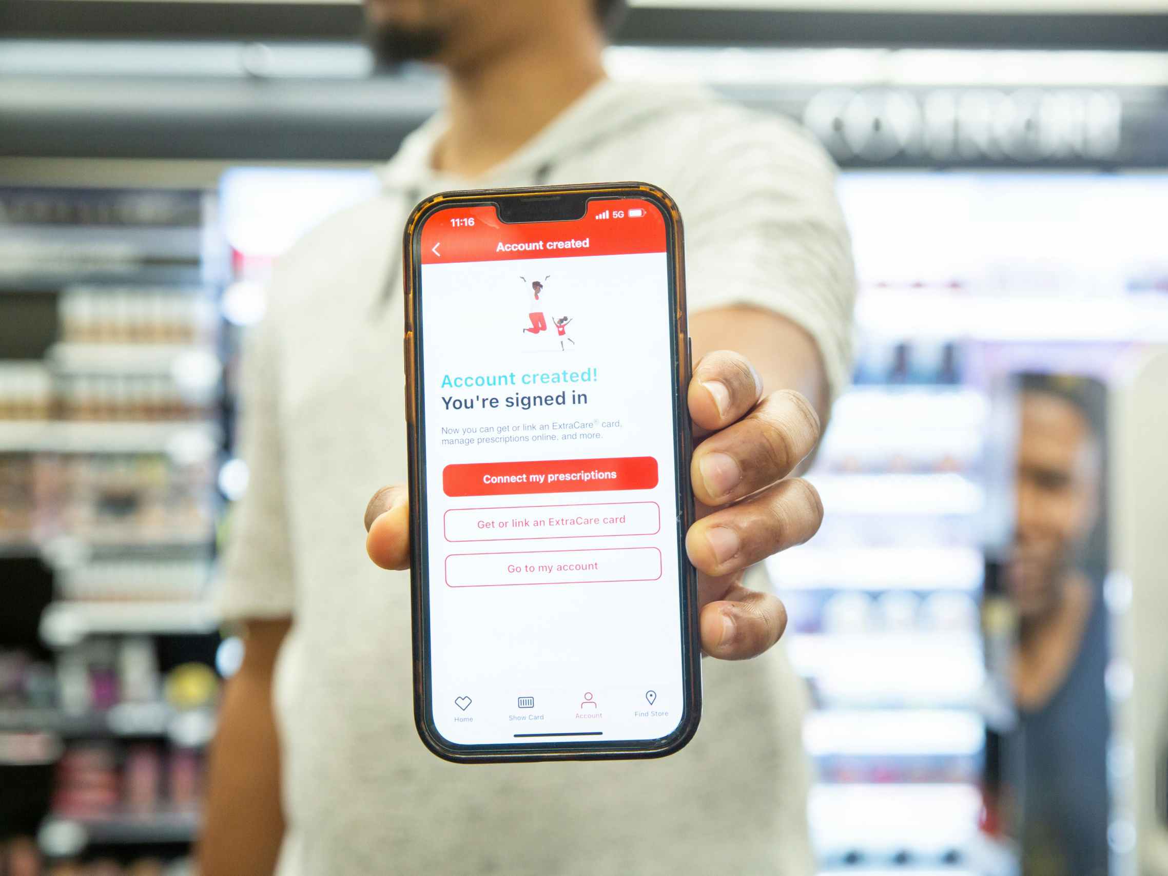 a person holding up a phone in a cvs