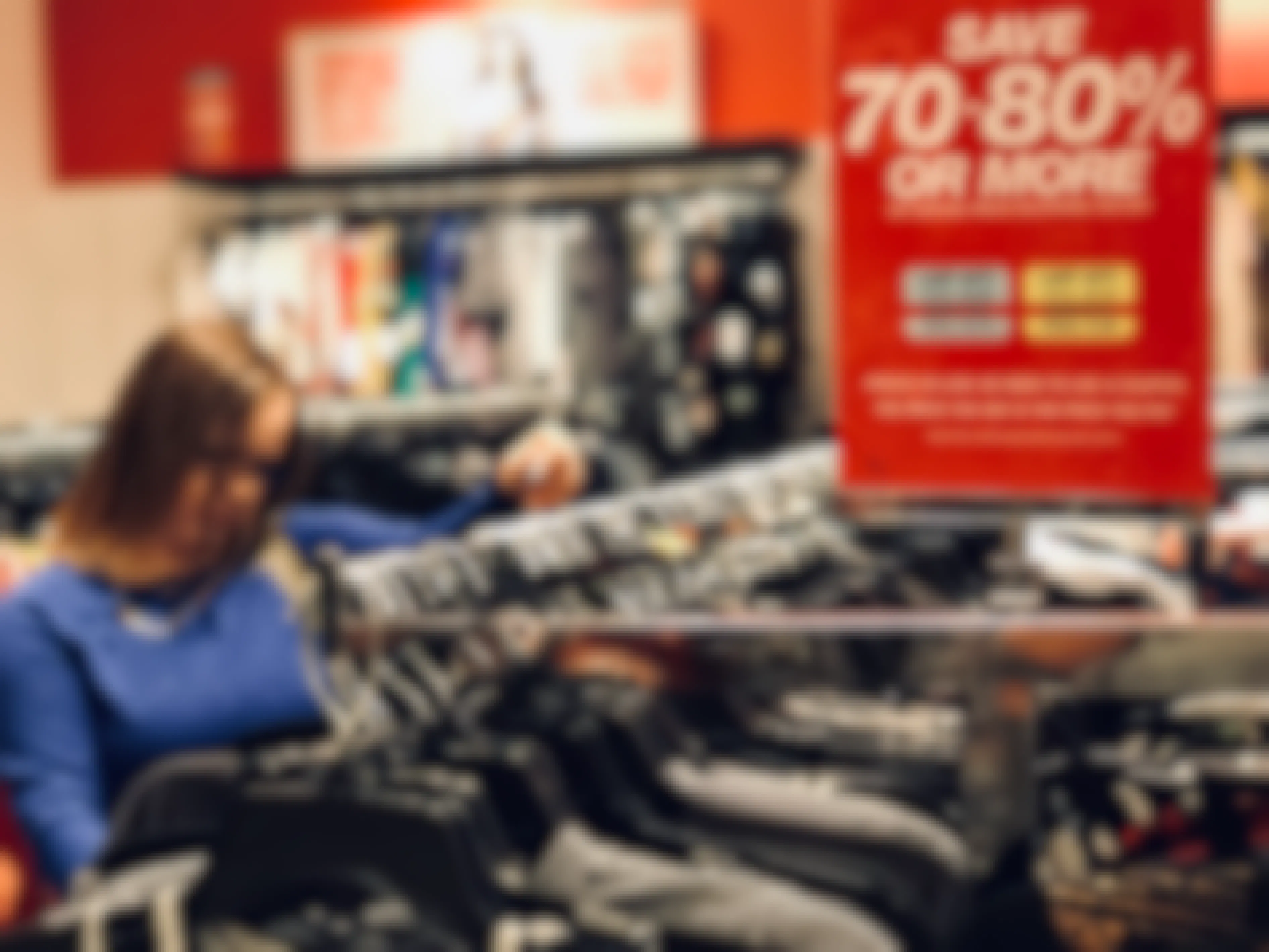 woman shopping through clothes on macys clearance rack
