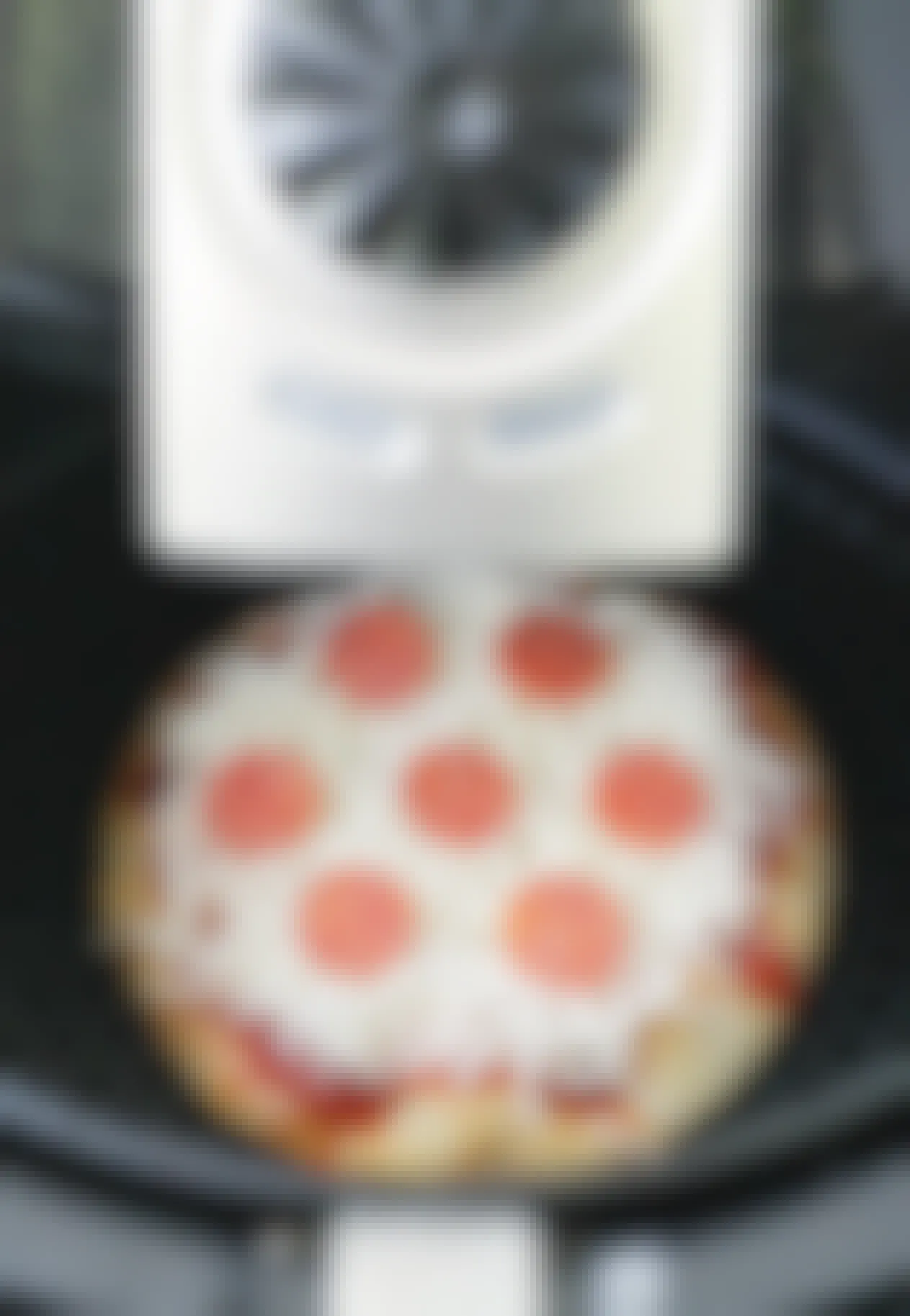A personal pizza being cooked in an air fryer