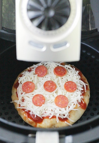 A personal pizza being cooked in an air fryer