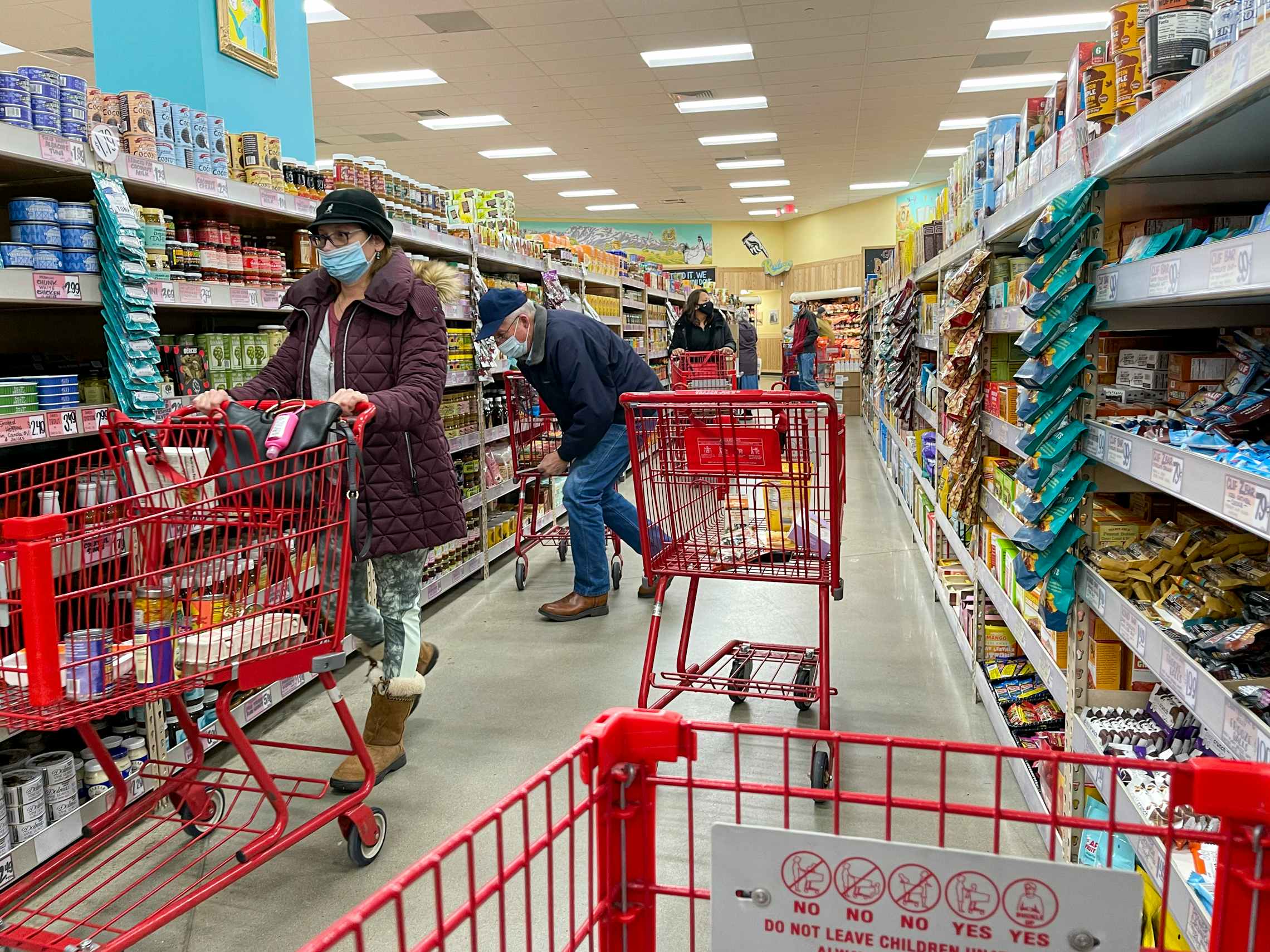 Customers in a busy shopping aisle inside Trader Joe's.