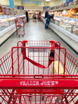 A shopping cart in the center of an aisle at Trader Joe's