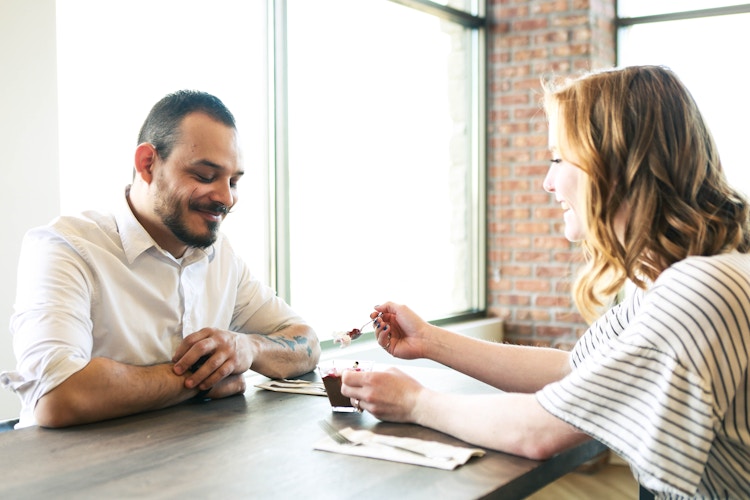 a couple eating dessert at a table 