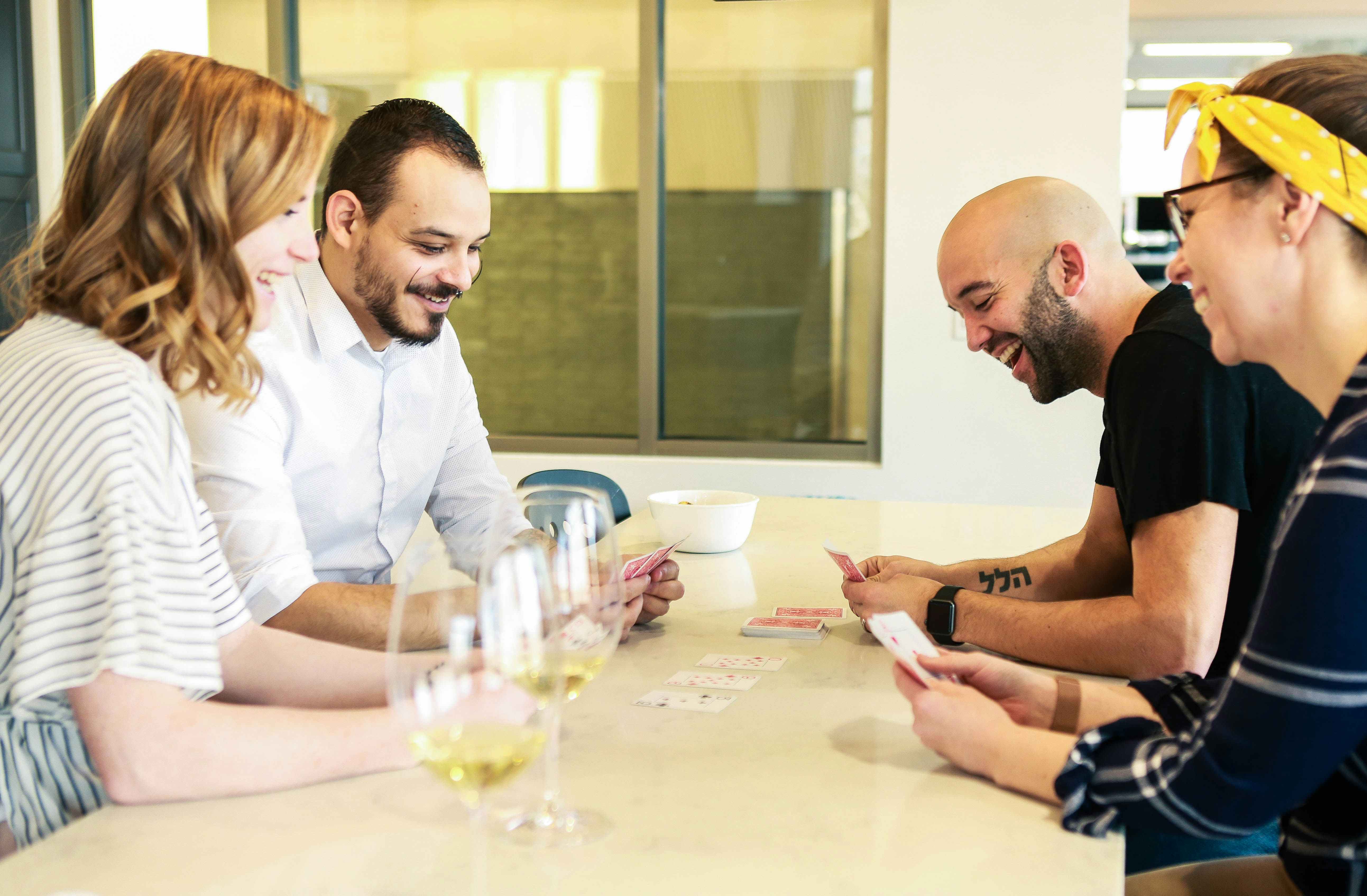 two couples playing card games at a table 