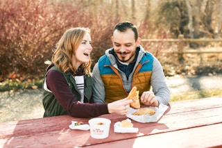 a couple eating at a picnic table