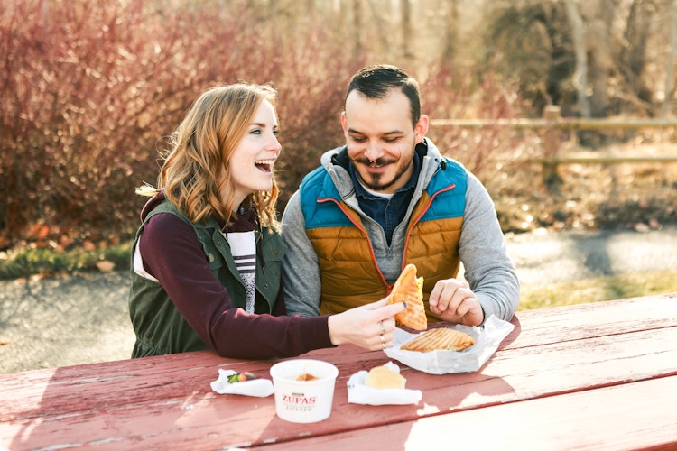a couple eating at a picnic table 