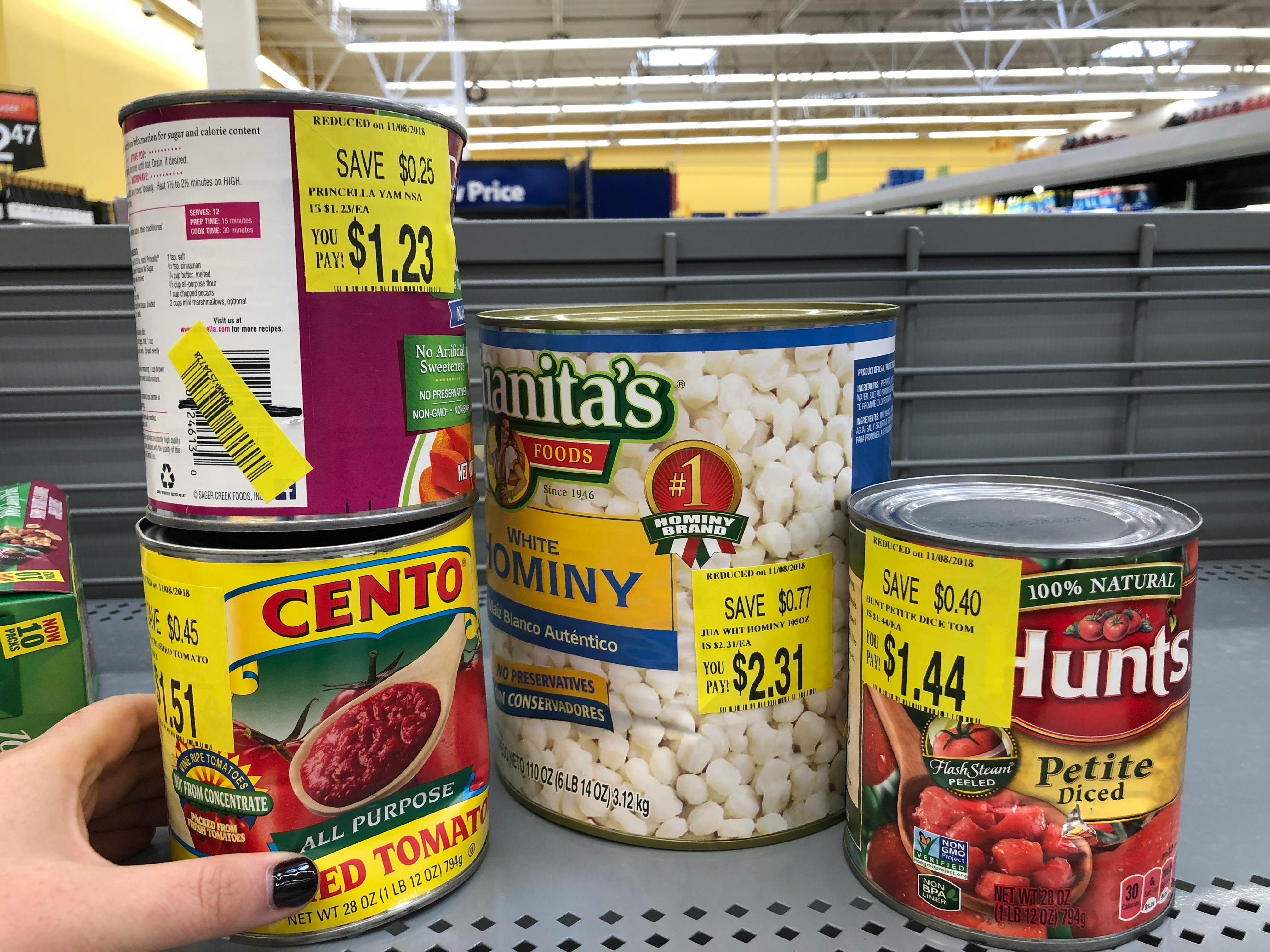 person looking at dented canned goods in walmart clearance aisle