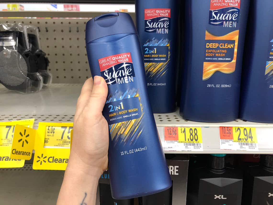 left hand holding bottle of suave men 2-in-1 hair and body wash in front of suave men shelves at walmart