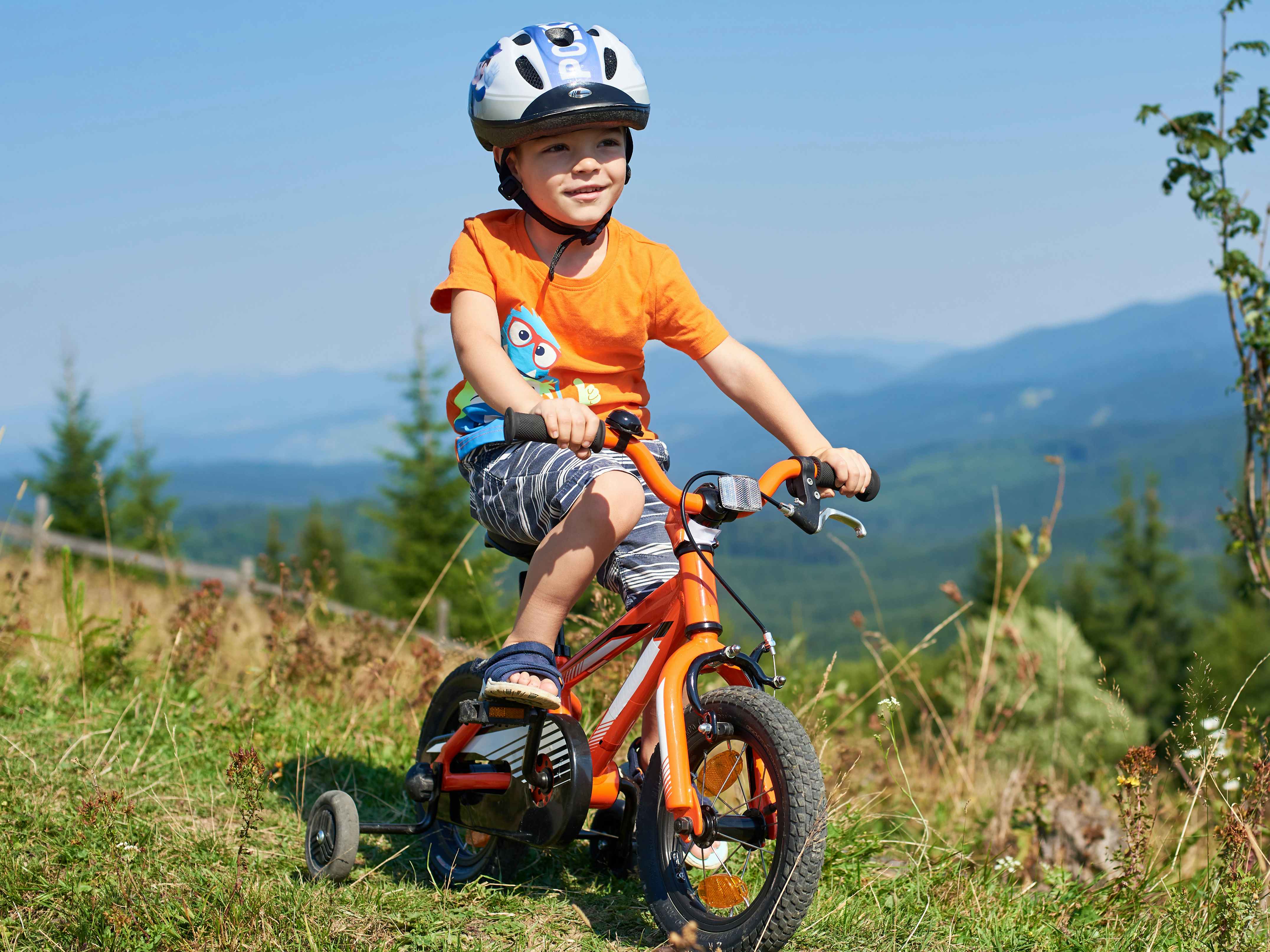 a child riding on a bike wearing a helmet