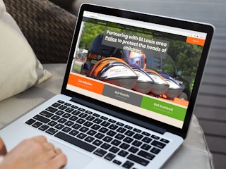 a person looking at the helmets first website on their macbook