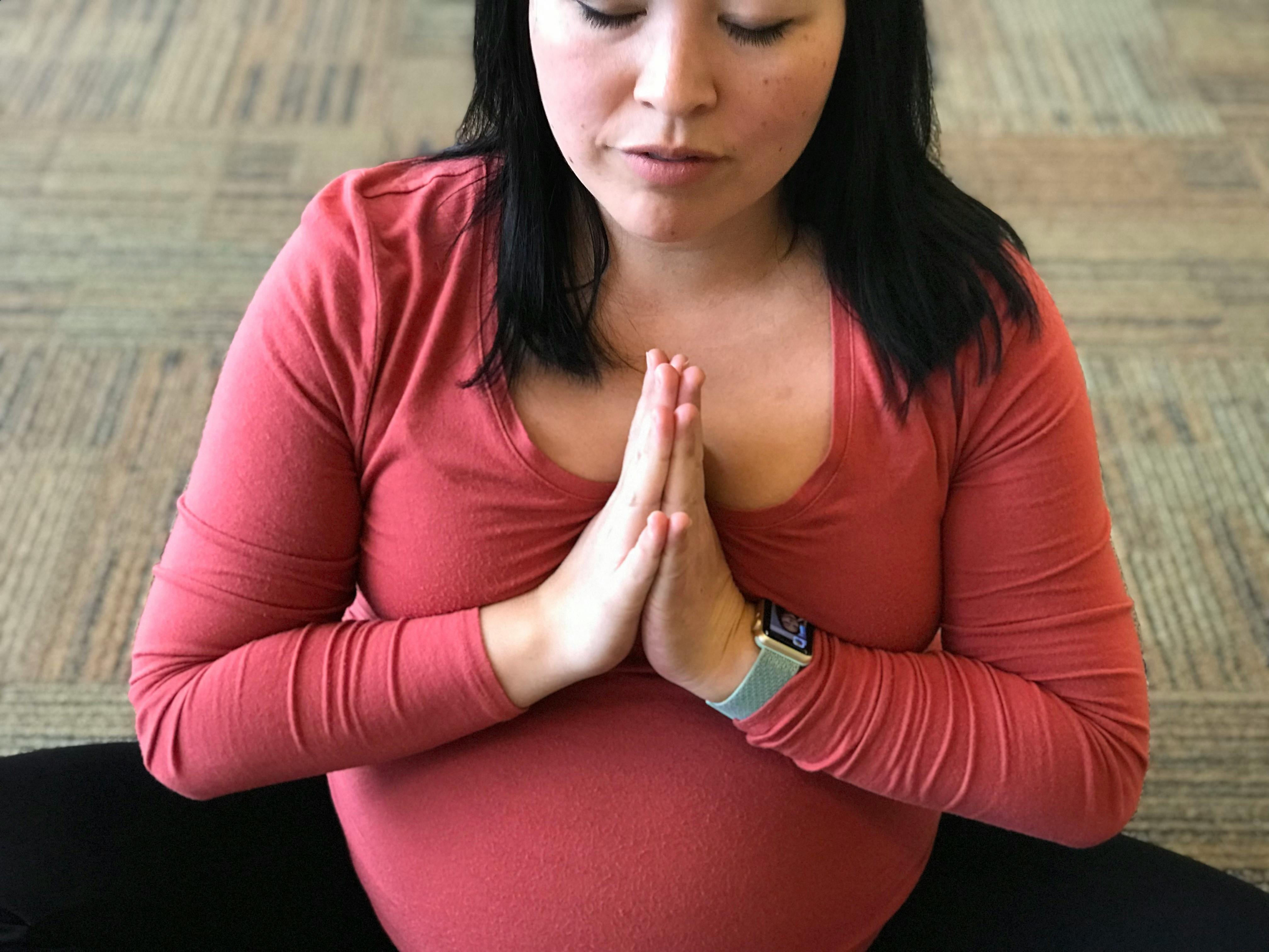 woman hands in prayer eyes closed meditating