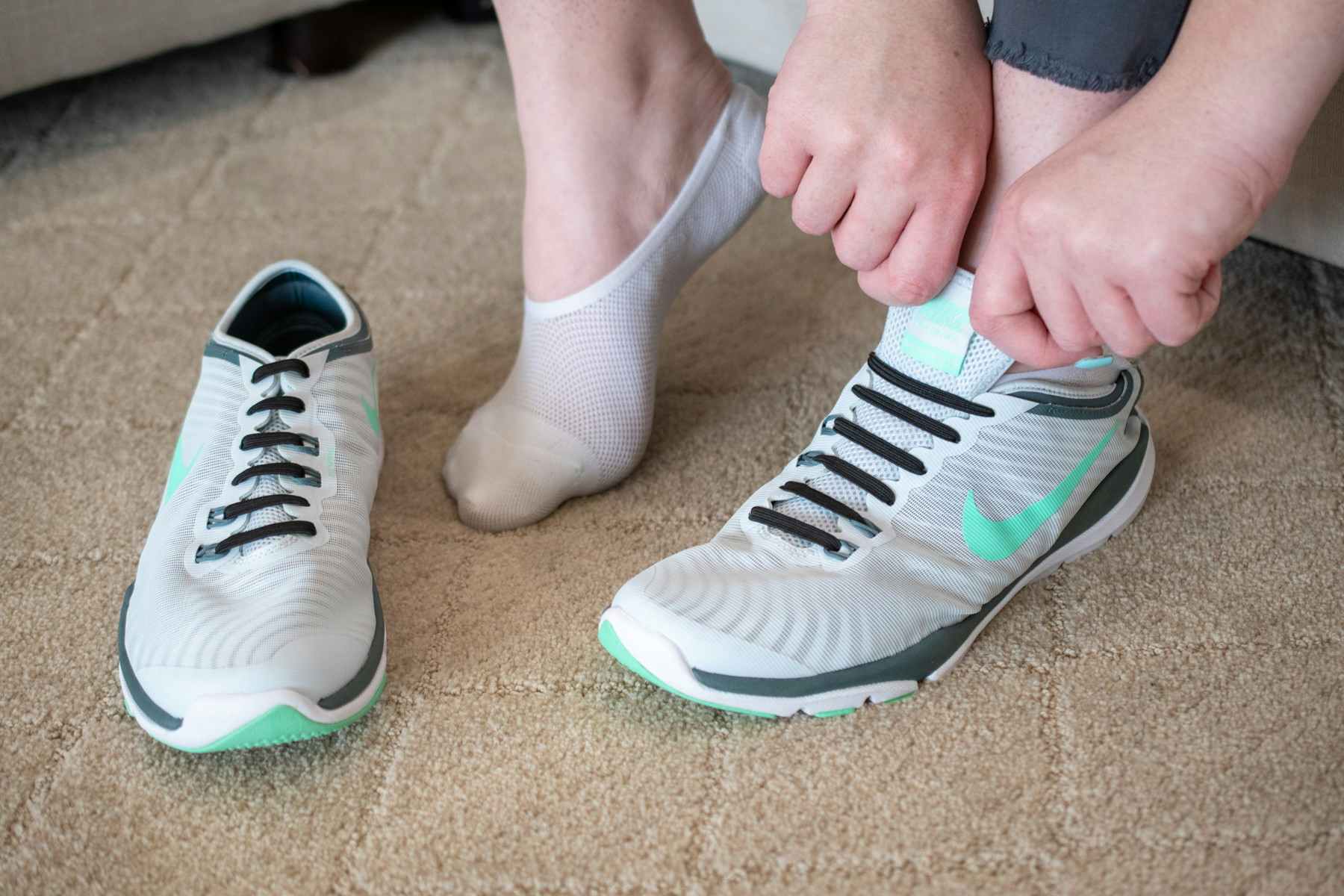 A person putting on a tennis shoe.