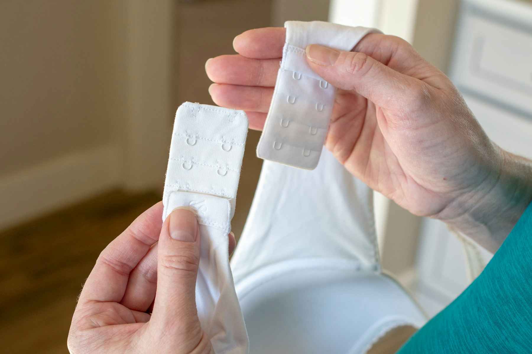 A person holding bra extenders on a bra.