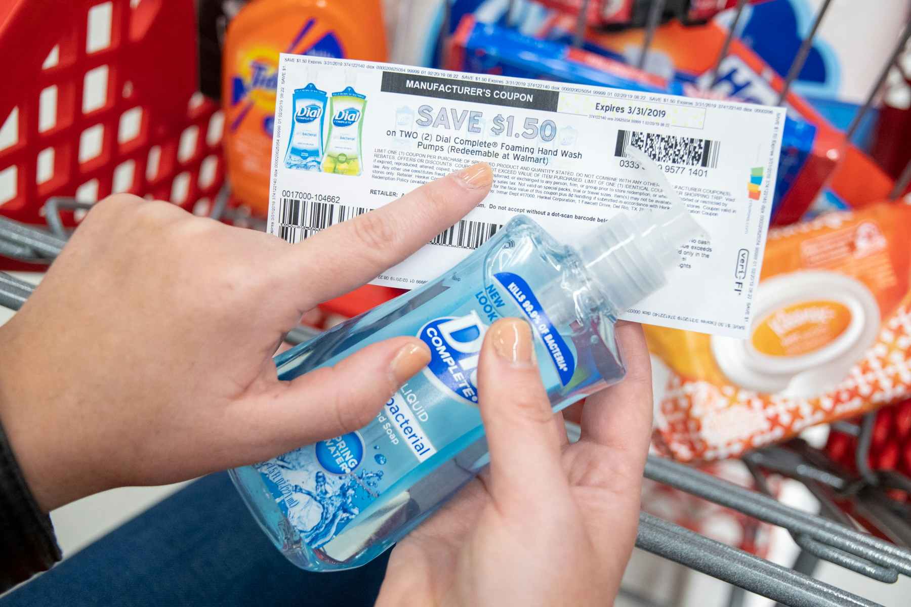 Woman pointing out fine print on coupon while holding a bottle of hand soap