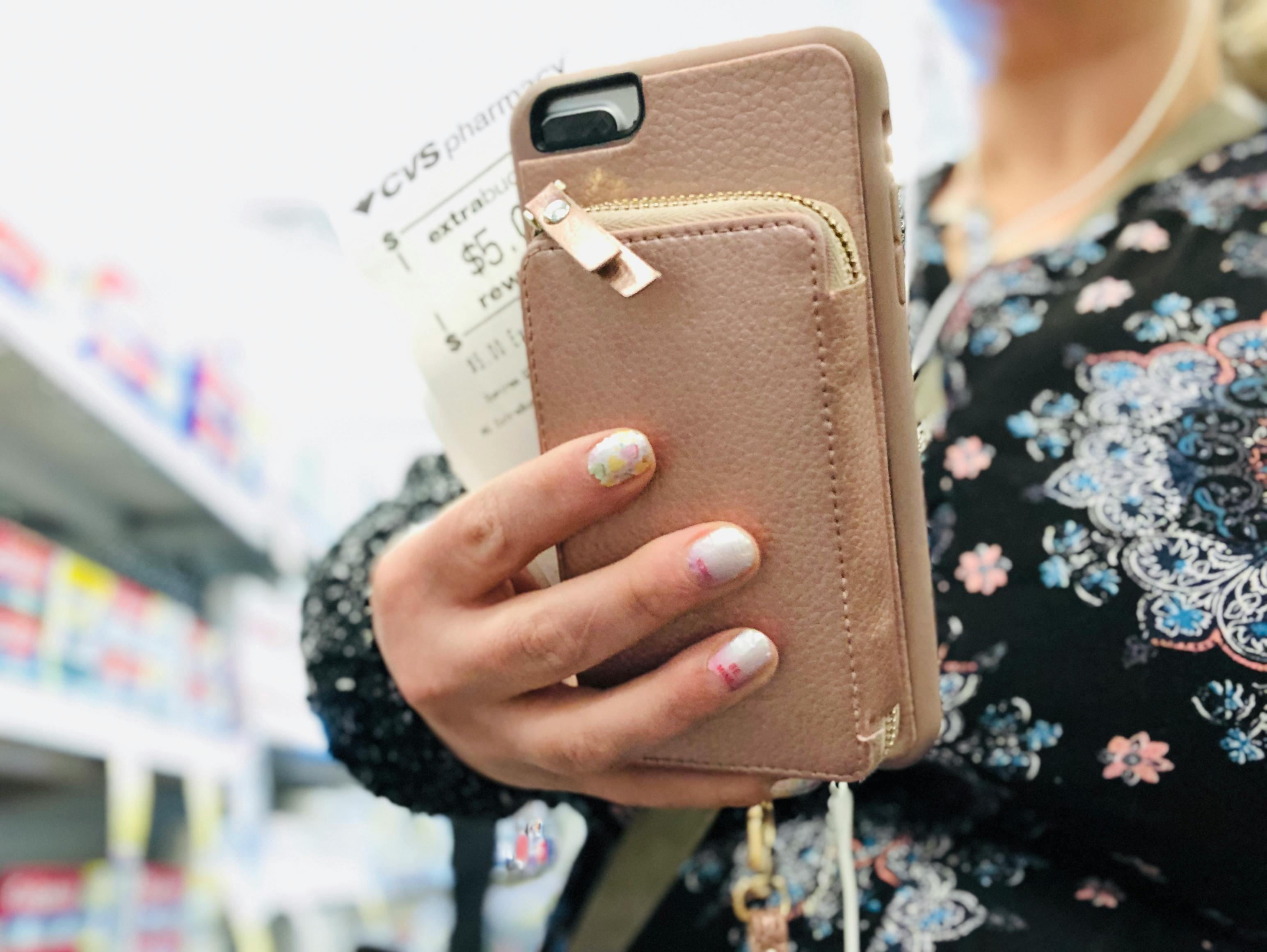 someone holding cvs extrabucks and phone