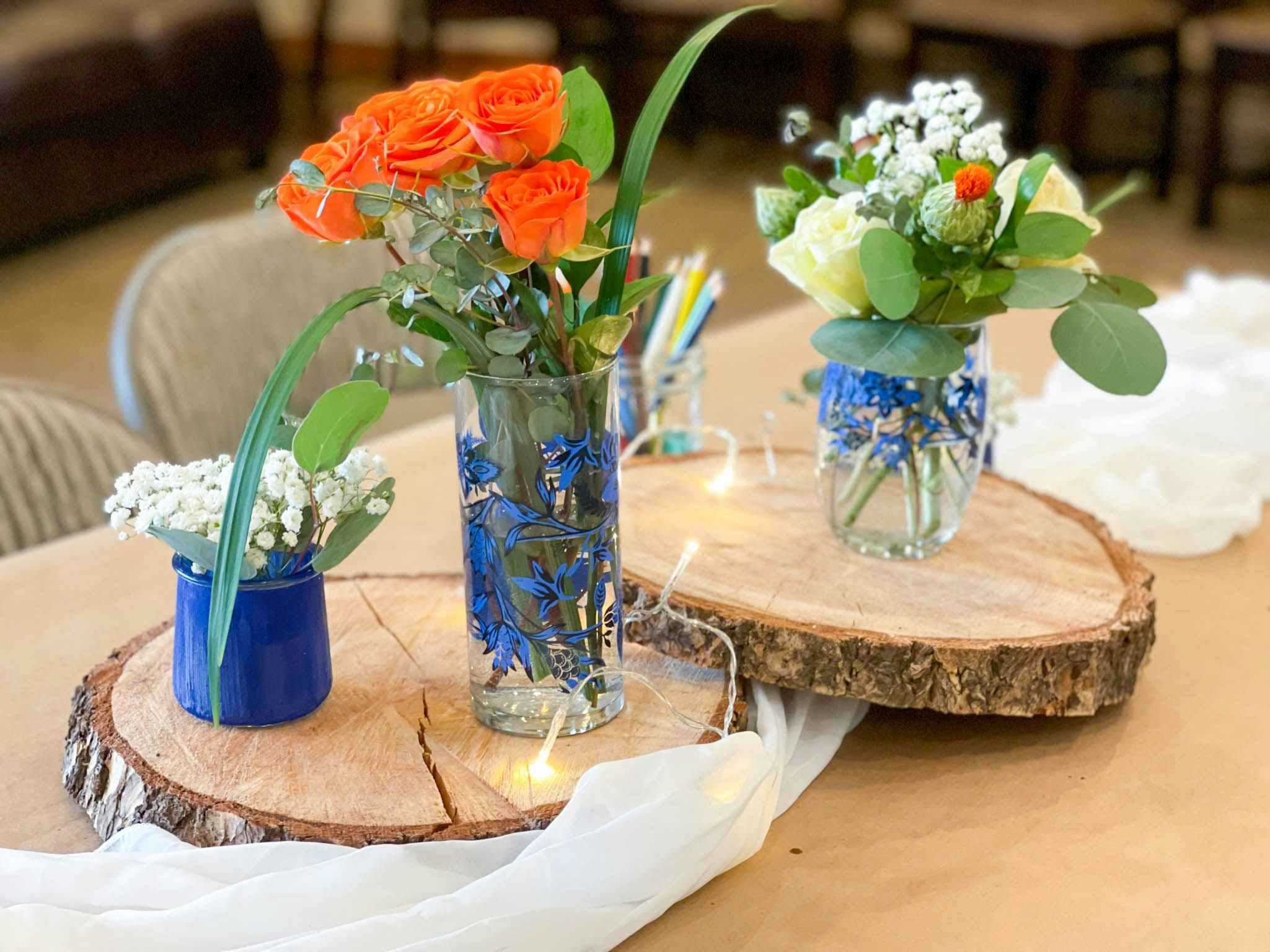 Flowers in vases on slices of wood.