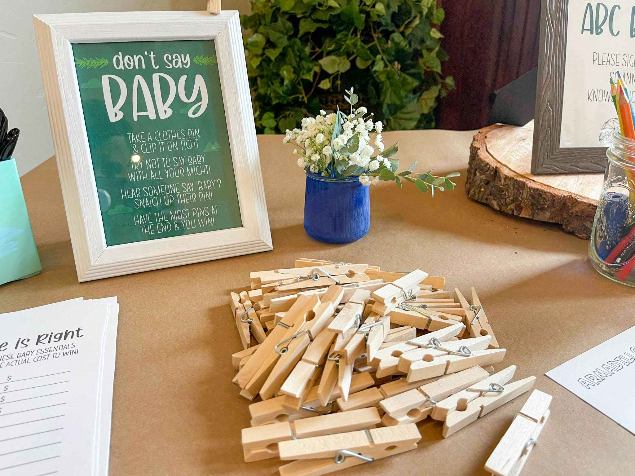 Clothes pins on a table next to a sign that say "Don't say baby" with game instructions.