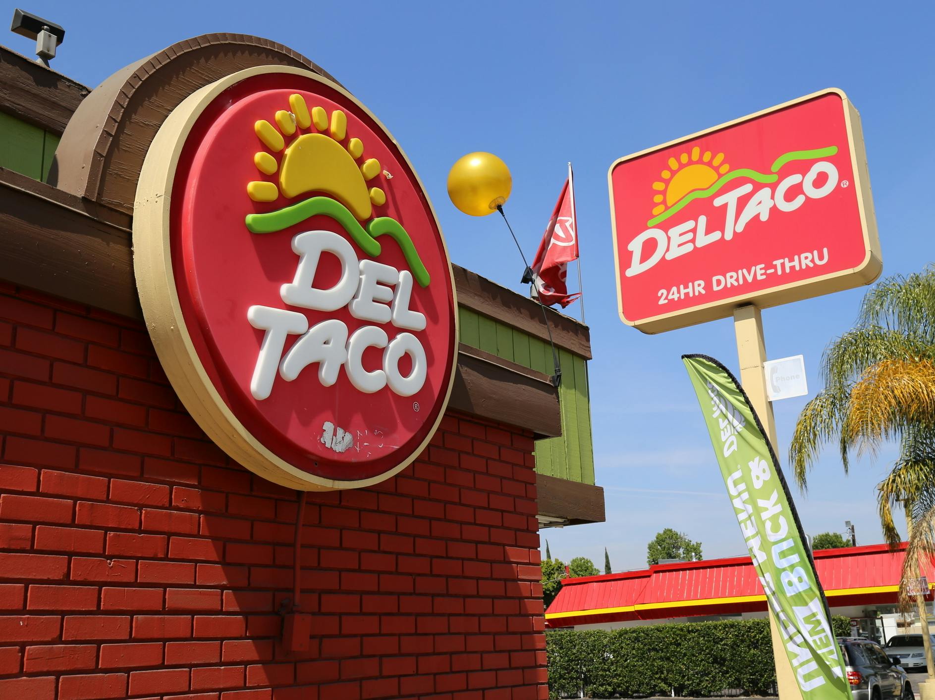 A Del Taco sign and restaurant exterior.
