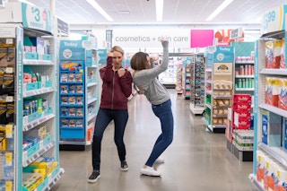 Two women celebrating in the aisles of a Walgreens store