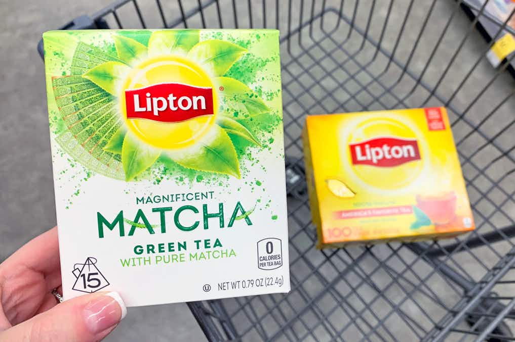 Someone putting Lipton tea into a grocery cart