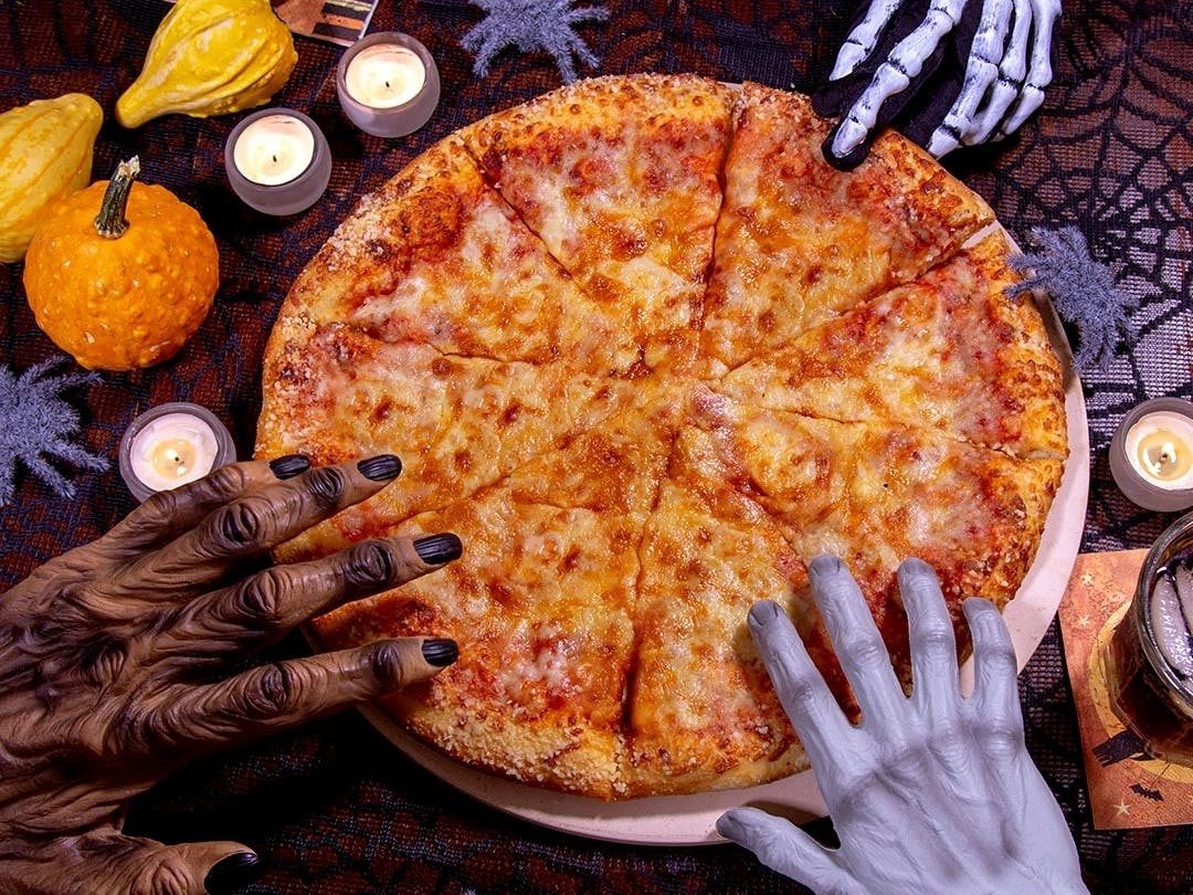 Some spooky hands reaching for a pizza from Marco's Pizza