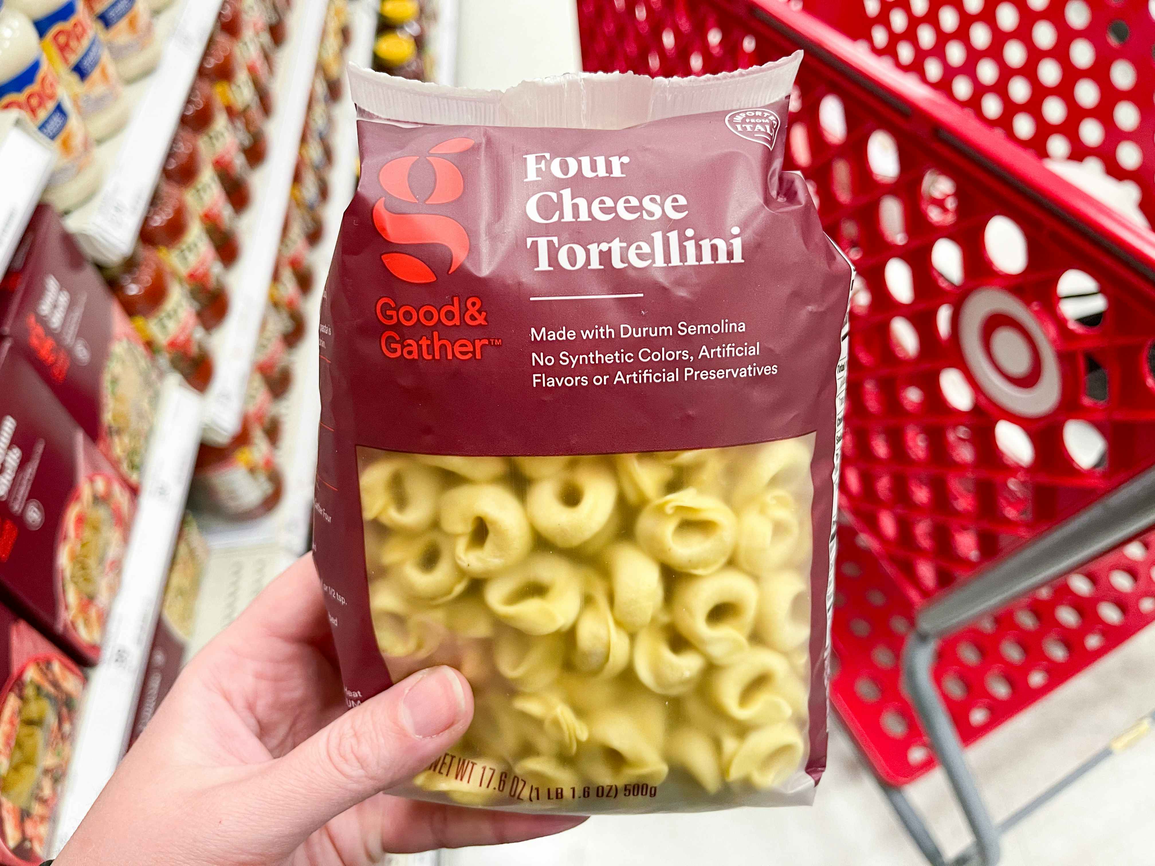 A person holding a package of Good and Gather tortellini, on the pasta aisle inside Target
