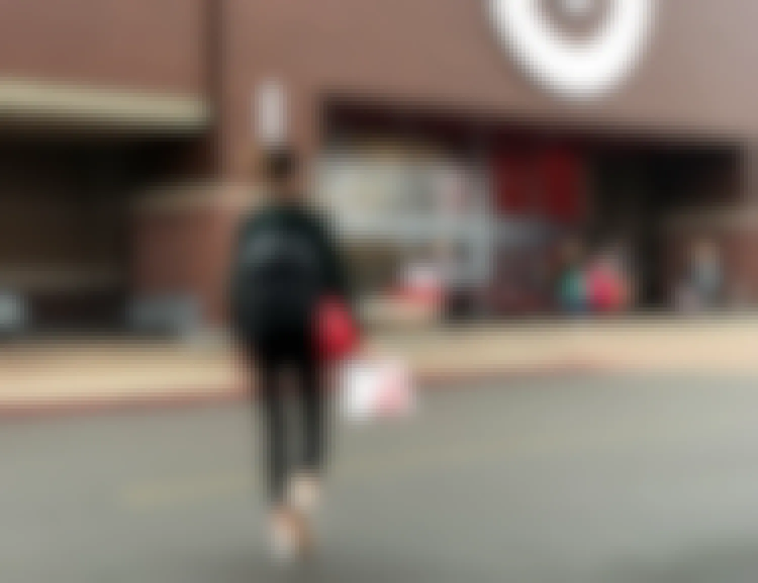 A person carrying a target bag walking toward the Target entrance.