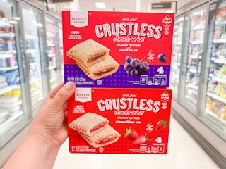 Someone holding two boxes of Market Pantry crustless sandwiches at Target