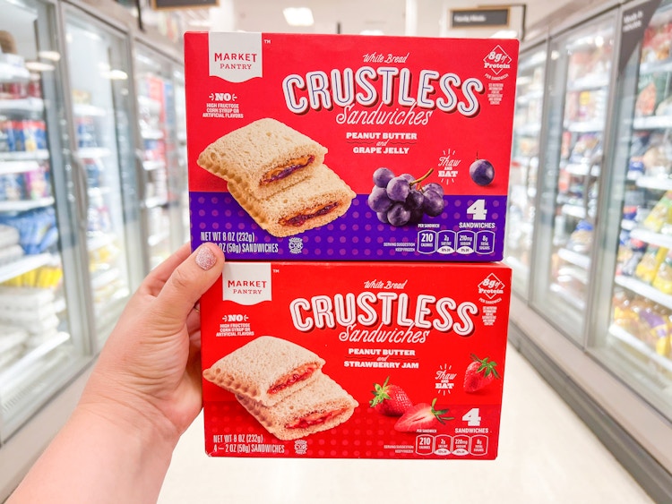 Someone holding two boxes of Market Pantry crustless sandwiches at Target