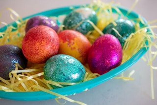 Decorate Easter eggs using a plastic bag, food coloring and glitter.