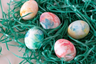 Decorate eggs by swirling them in food coloring and whipped topping.