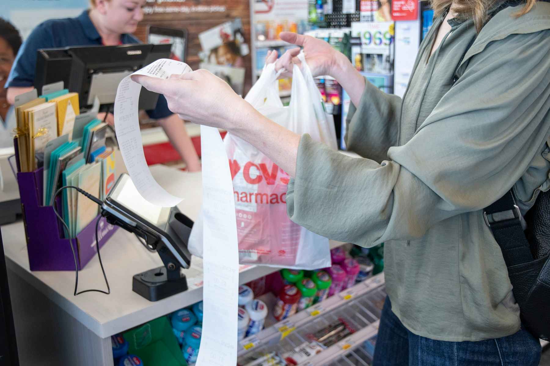 A person holding a very long CVS receipt after checkout