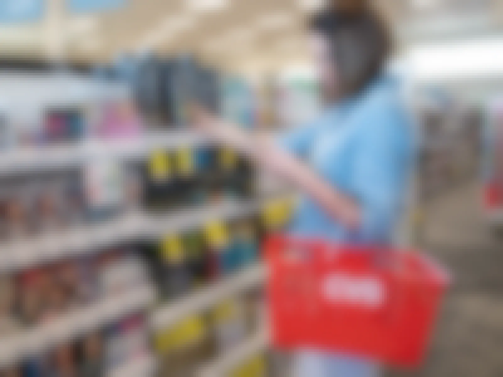 A woman carrying a CVS basket and shopping in CVS.