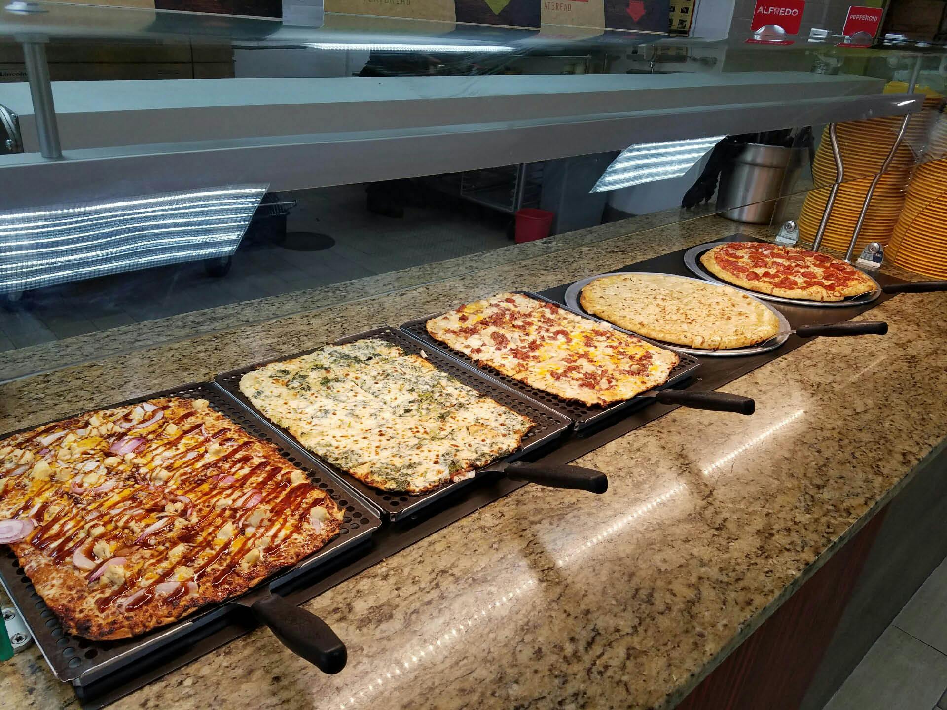 Cici's buffet with several different square pizzas on display